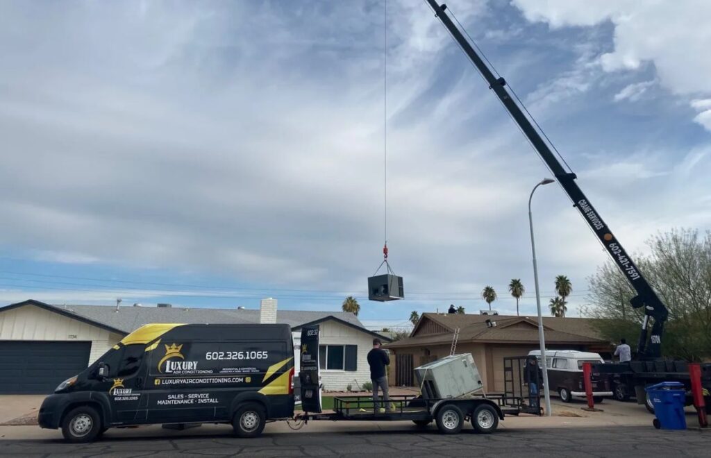lacp-img-12 Technicians using a crane to install an air conditioning unit on a residential roof. Luxury Air Conditioning services.