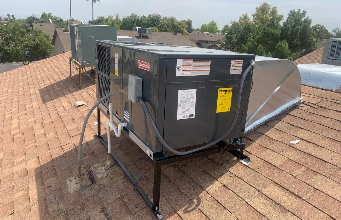 Goodman rooftop HVAC unit installed on a sloped shingle roof, providing efficient cooling and ventilation.