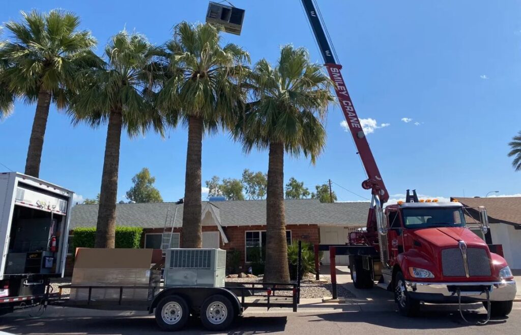 lacp-img-16 A crane lifts equipment above palm trees during a construction project in a sunny residential area.