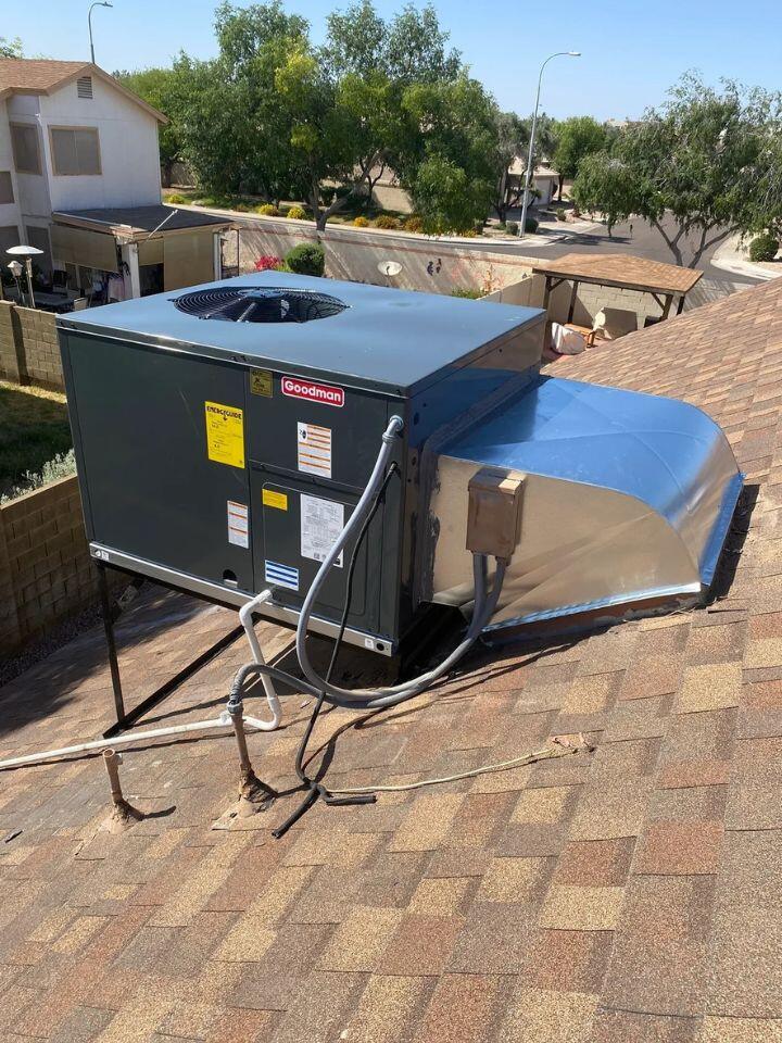 lacp-img-20 Goodman rooftop HVAC unit installed on a residential roof, showcasing efficient air conditioning setup.